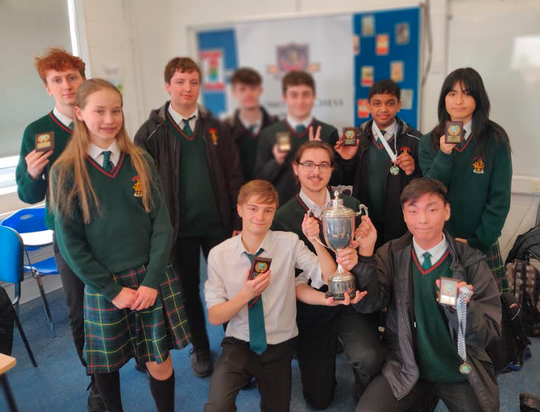 Chess club team members holding a cup